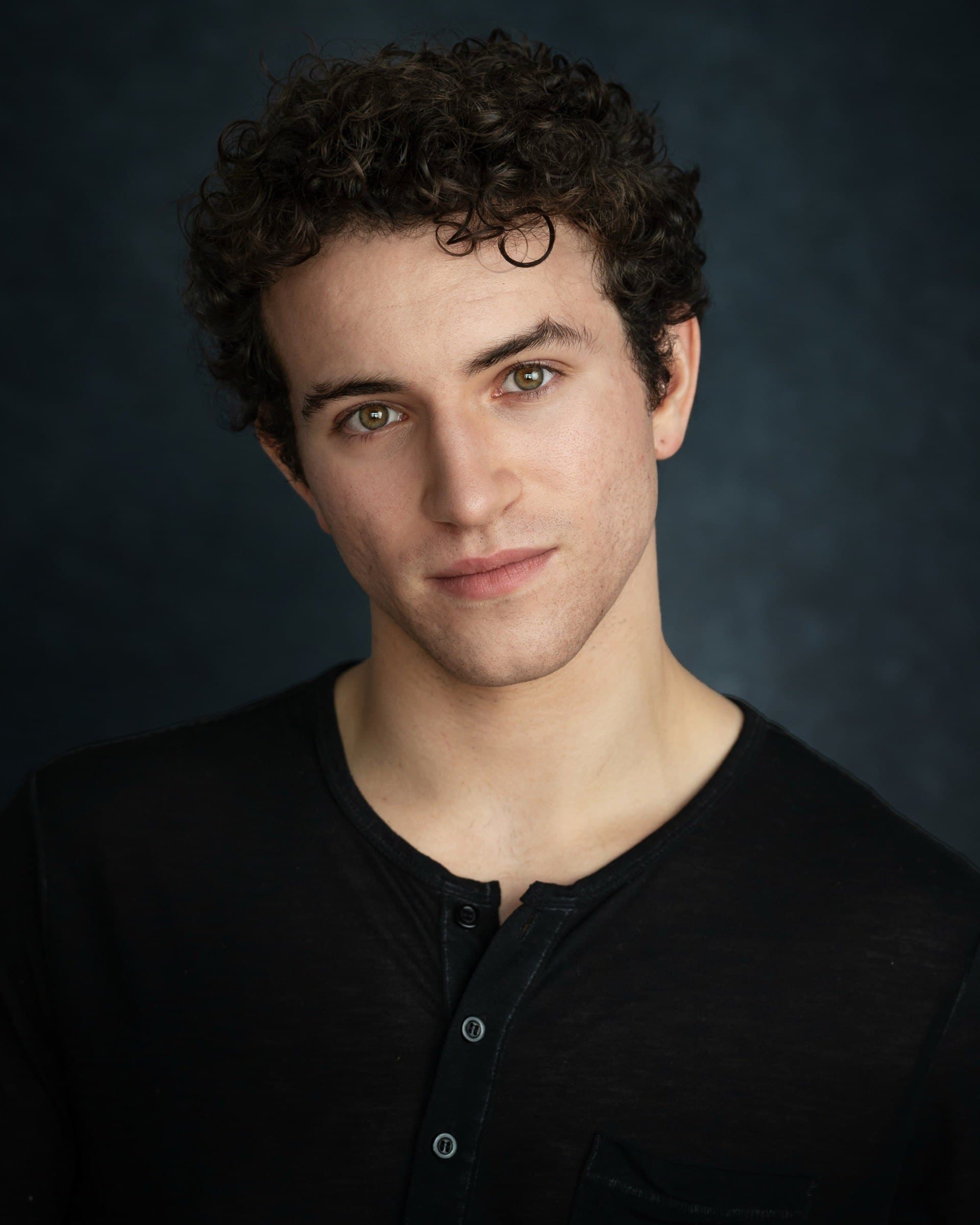 AJ DeAugustine, headshot in a black henley