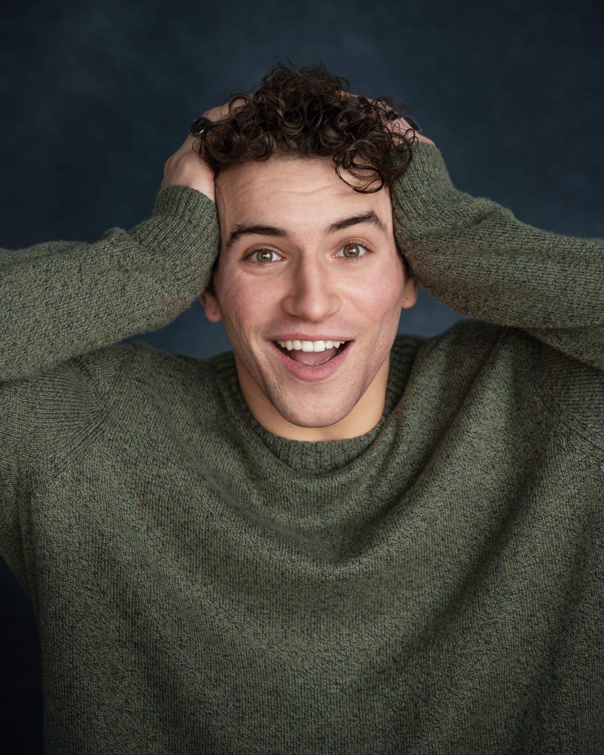 AJ DeAugustine, smiling with hands in his hair
